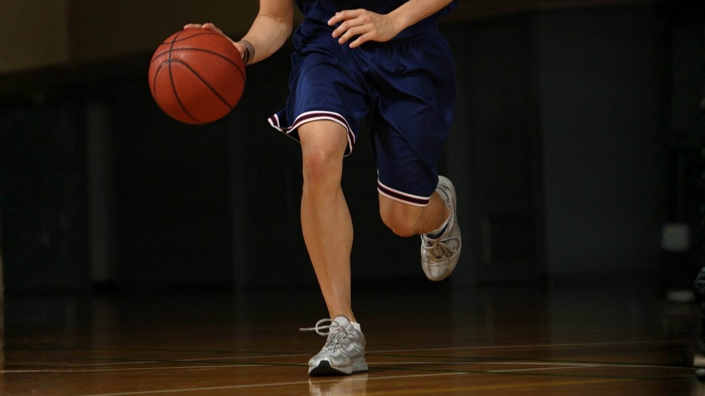 Young basketball player dribbling ball.